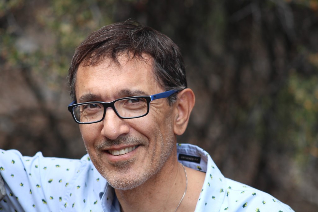 Close-up portrait of Dr. Novak smiling and wearing glasses.