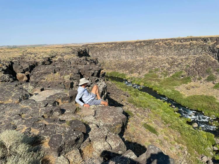 Dr. Novak hiking in a rocky canyon landscape, showcasing a peaceful moment in the Oregon wilderness.